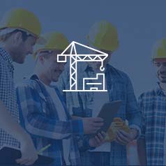 Four men standing in hard hats and flannel shirts looking at a tablet working with Acumatica ERP software at a construction site