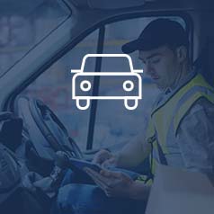 Man with yellow work vest on sitting in a semi truck using a tablet and working with Acumatica ERP software for transportation